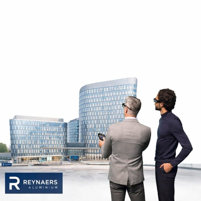 Architects observing modern glass façade building with Reynaers Aluminium systems.