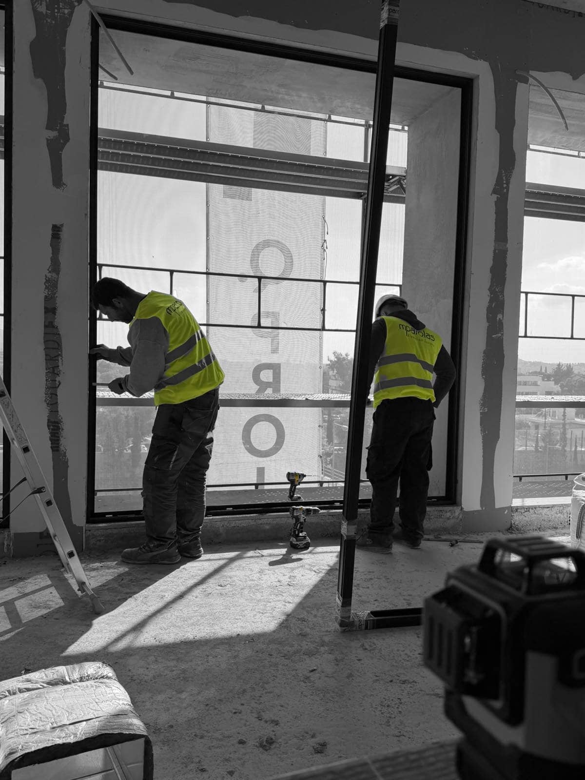 Mparolas technicians installing minimal aluminium window frames at the MOB1 commercial building during on-site installation.