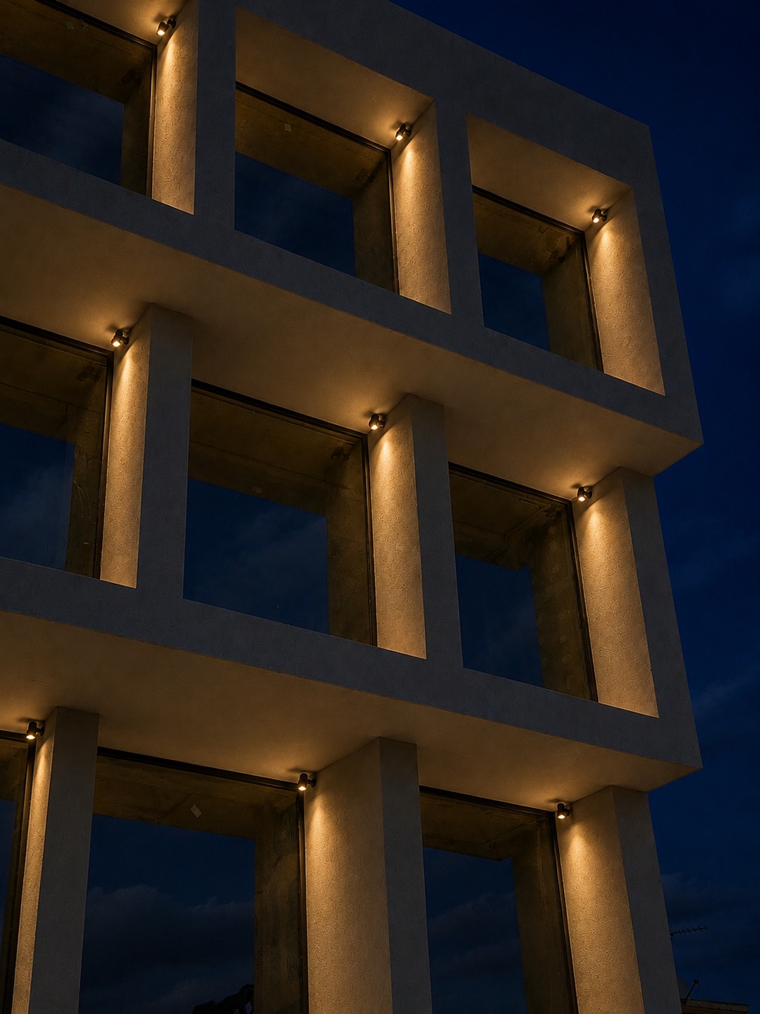 Premium minimal aluminium window systems on the MOB1 building façade during evening architectural lighting.