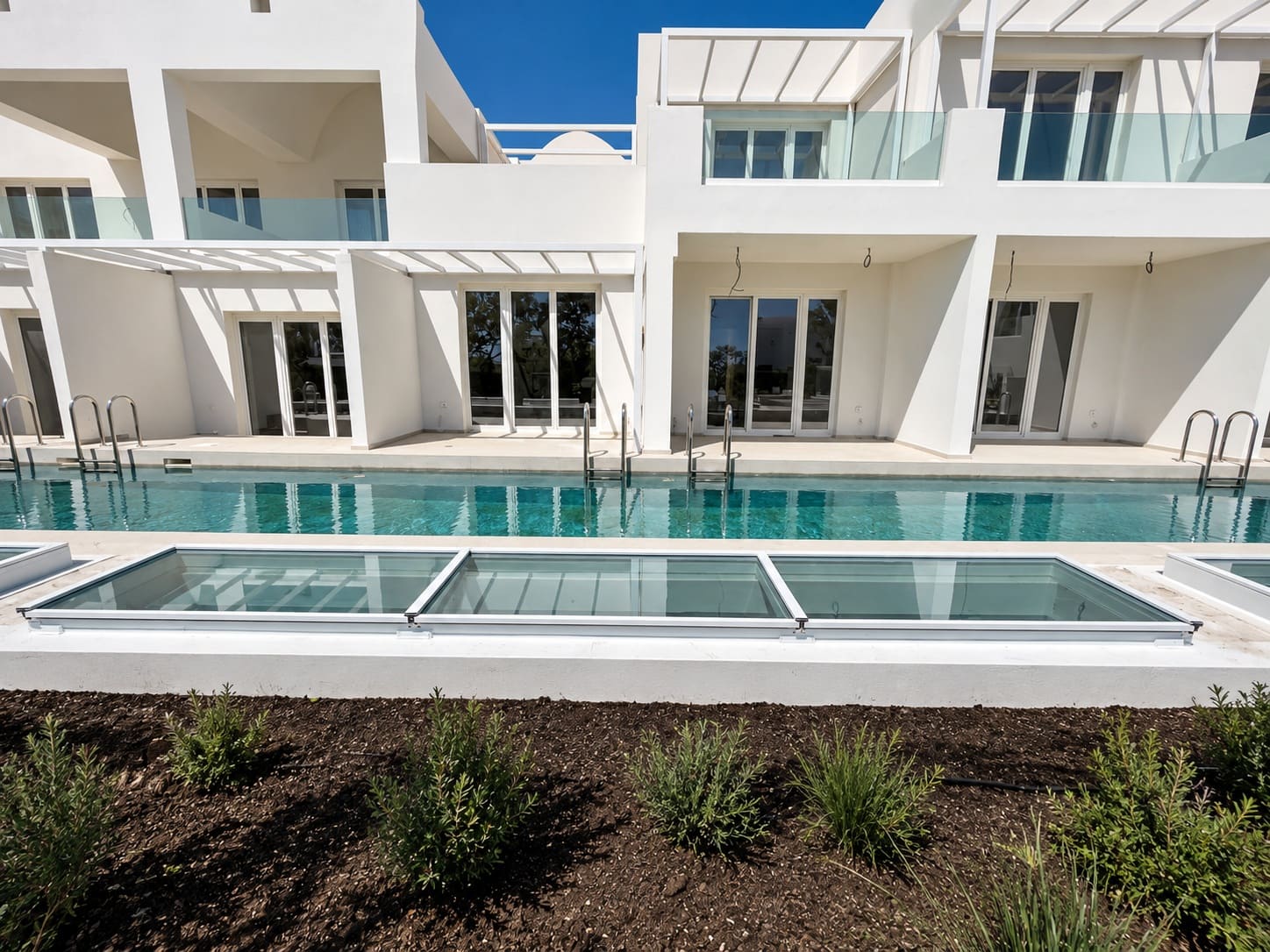 Glass aluminium atriums beside pool at Santorini Heart Hotel and Spa