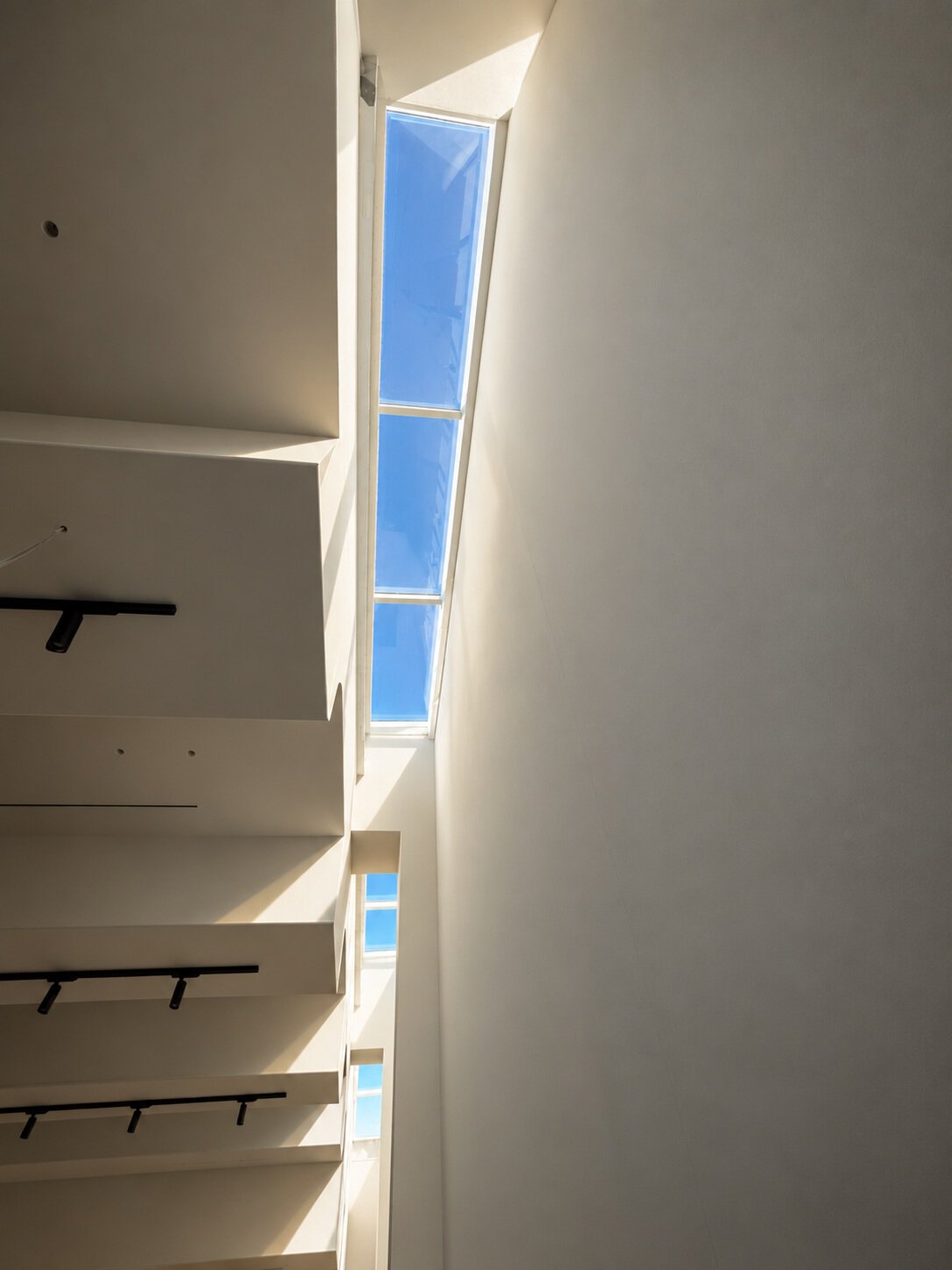 Natural daylight entering hotel interior through narrow glass aluminium skylight in Santorini