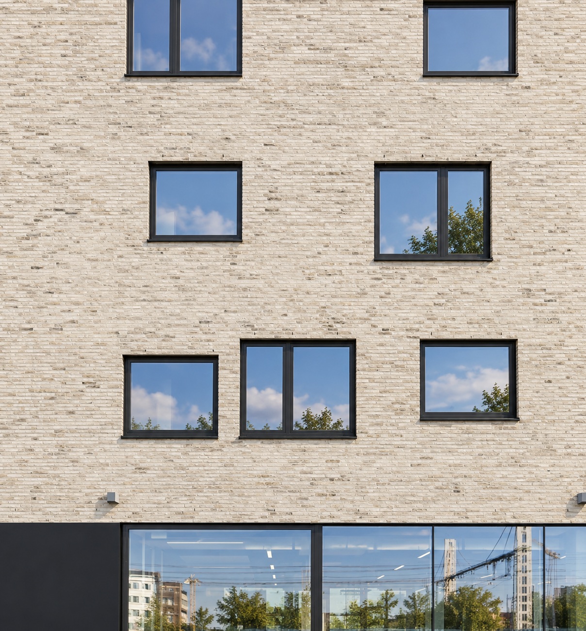 Reynaers MasterLine 10 aluminium windows with dark frames integrated into a contemporary light brick building façade