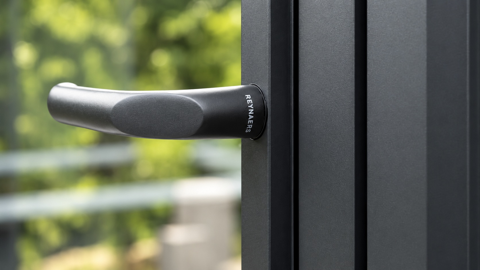 Reynaers Touch anthracite window handle with ergonomic minimalist design mounted on a dark aluminium frame